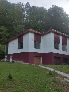 a red and white building with a grass yard at Rent Olamit in Šančiai