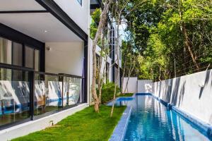 a house with a swimming pool next to a building at 3BR Penthouse with Rooftop Pool Near Centro in Tulum