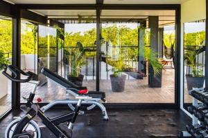 a gym with a bike in front of a glass door at 3BR Penthouse with Rooftop Pool Near Centro in Tulum