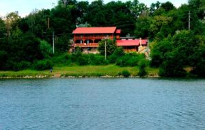 a house on the shore of a lake with a building at Penzion Na přehradě in Smradávka