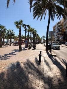 a sidewalk with palm trees and a street with cars at Luxury Apartment in Fuengirola
