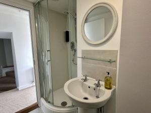 a bathroom with a sink and a shower and a mirror at Wothorpe House, 4 bed, Stamford Centre by Belmont Places in Lincolnshire +34 photos
