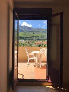 a door open to a balcony with a table and chairs at El Mirador de Hervas in Hervás