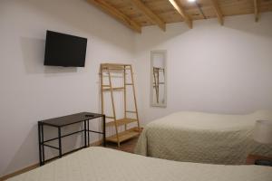 Rancho Agua BlancaCabañas Los Alpes Campestres的客房设有两张床和一台墙上的电视