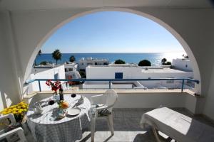 a balcony with a table and a view of the ocean at Pissouri Beach Apartments in Pissouri