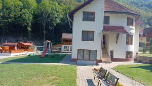 una casa con parque infantil y patio de juegos en Pensiunea Casa David, en Şugag