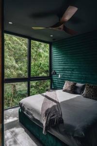 图卢姆Luxury Villa, Beach Club - Jungle View - Sahara Jade的一间卧室，里面有一张床和一个吊扇