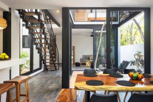 a kitchen and dining room with a table and a staircase at Private Rooftop Pool - Bike to Ruins or Beach in Tulum