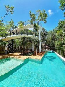 a swimming pool with a building in the background at Private Rooftop Pool - Bike to Ruins or Beach in Tulum