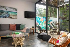 a living room with a couch and a glass table at Private Rooftop Pool - Bike to Ruins or Beach in Tulum