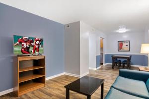 Una sala de estar con un sofá y un televisor. en HomeTowne Studios by Red Roof Huntsville - Madison, en Madison