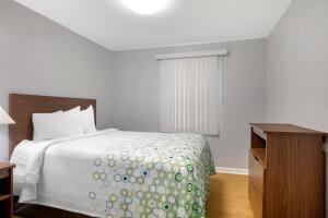 Un dormitorio con una cama y una cómoda y una ventana. en HomeTowne Studios by Red Roof Huntsville - Madison, en Madison 27 fotos más