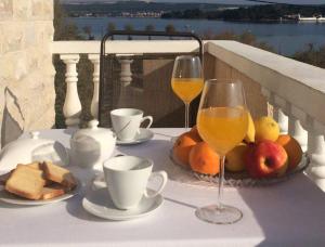 a table with two glasses of wine and some food at Apartments Esperanza in Pašman