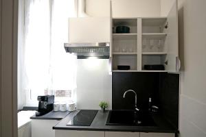 イヴリー・シュル・セーヌにあるAppartement cosy à 10 min de Parisのシンクとカウンタートップのあるキッチン