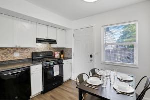 a kitchen with white cabinets and a table with chairs at The Northtowne Getaway in Columbus +15 photos