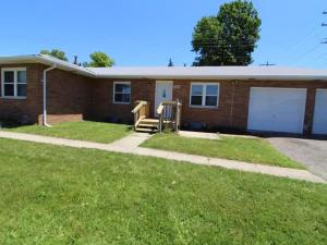 a brick house with a porch and a yard at The Northtowne Getaway in Columbus