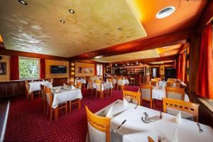 a dining room with white tables and chairs at JazzPenzion in Čadca