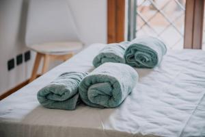 un gruppo di asciugamani appoggiati sopra un letto di Poccio House a Fiumicino Altre 27 foto
