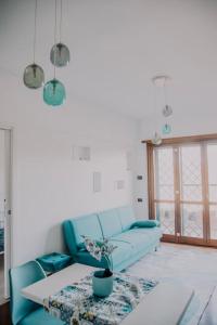 un soggiorno con un divano blu e un tavolo di Poccio House a Fiumicino