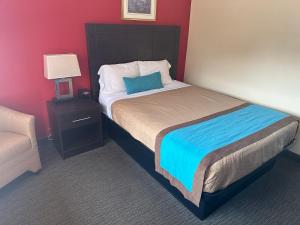 a bedroom with a large bed with a blue pillow at All Seasons Motel in Port Elgin