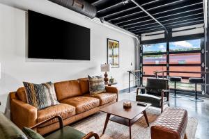 a living room with a couch and a flat screen tv at Downtown Kentucky Home Perfect for Groups in Louisville