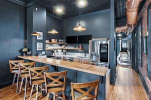 a kitchen with blue walls and a bar with stools at Downtown Kentucky Home Perfect for Groups in Louisville