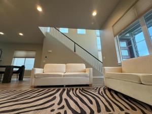 奥罗拉New Modern Contemporary House by The Airport and Gaylord Resort的客厅配有2张白色沙发和地毯。