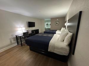 a hotel room with a bed and a desk with a television at Lakeside Inn in Guntersville