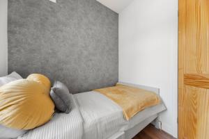 a bedroom with a bed with yellow and white pillows at Luxury 3-BR Home-Driveway, Sky-TV-Fast WiFi in Meanwood