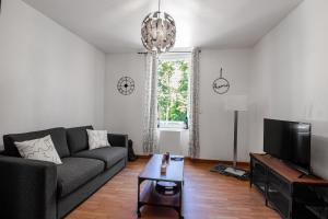 a living room with a couch and a tv at Sweet-patio in Briey +5 photos