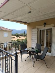 a patio with a table and chairs on a balcony at Eirini- Ioanna in Sami