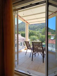 a patio with a table and chairs on a balcony at Eirini- Ioanna in Sami