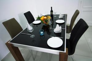 a black table with black chairs and a bottle of wine at Pissouri Beach Apartments in Pissouri