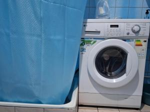 a washing machine with a blue shower curtain next to it at Terrace on Orbeliani in Tbilisi City +36 photos