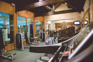 a gym with a bunch of treadmills and machines at Tre-Ysgawen Hall & Spa in Llangefni