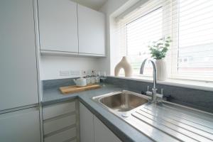 a kitchen with a sink and a window at Riverside Haven in Woodbridge in Woodbridge