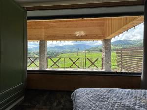 a bedroom with a window with a view of a field at Shahdag Nature House in Qusar