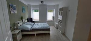 a bedroom with a bed and two windows at Ferienwohnung Gertraude in Markranstädt