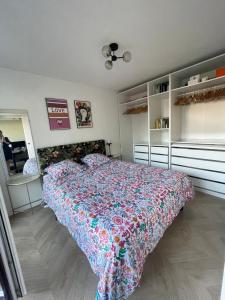 a bedroom with a bed with a floral bedspread at Appartement calme à Anglet in Anglet