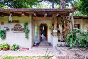 a house with a porch and a tree at Natural Retreat & Pet-Friendly Escape in Miacatlán