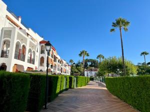 イスランティージャにあるApartamento en Islantilla playa con 2 terrazas y WIFI FIBRAの垣根付きの煉瓦造りの歩道