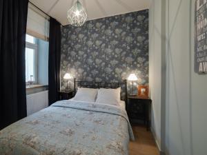 a bedroom with a bed with a floral wallpaper at Too-Good Premium Apartments in Krakow