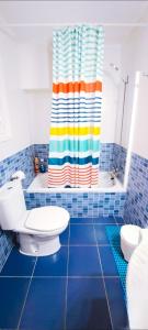 a bathroom with a colorful shower curtain and a toilet at Casa Ridao-Habitación Indalo con vistas in Mojácar +21 photos