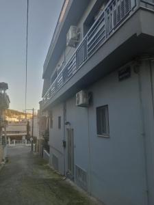 a white building with a balcony on the side of it at FLAT with Private Rooms in Agrinion