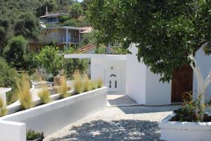 a garden with white walls and a tree at VILLA NOULI in Sarakiniko +74 photos