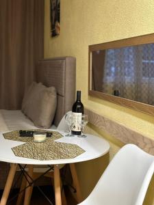 a table with a bottle of wine and a glass at Studio apartmani Anastasija in Žabljak