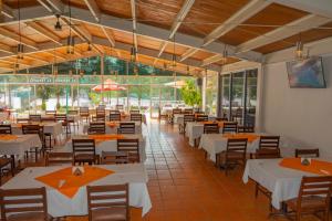 a restaurant with white tables and chairs and windows at Coral Clubes Santa María in Tlalmanalco de Velázquez