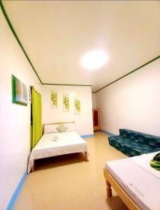 a room with two beds and a couch in it at Domos Native Guest House in Panglao Island