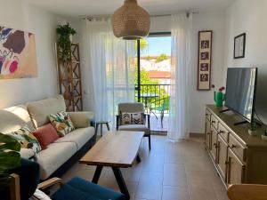 イスランティージャにあるApartamento en Islantilla playa con 2 terrazas y WIFI FIBRAのソファとテーブルのあるリビングルーム