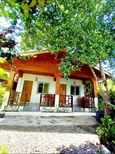 a house with chairs in front of it at Domos Native Guest House in Panglao Island